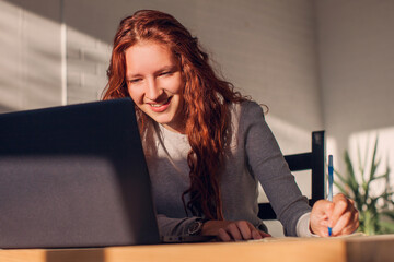 Young woman studying online on laptop at home