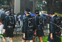 大雨の中を祭りに参加した人々