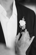 Woman girl's hand attaches flower boutonniere to men's suit