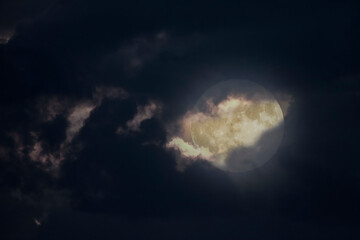 Wall Mural - full moon seen through a hole in the night clouds