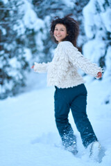 Wall Mural - The woman having fun walking in snow covered winter forest