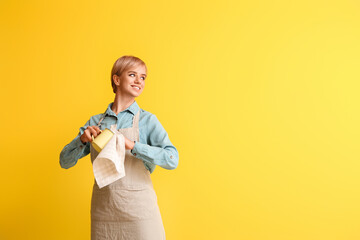 Wall Mural - Female barista with cup and napkin on yellow background