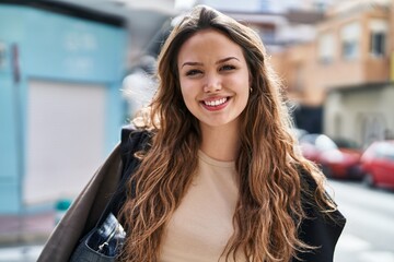 Wall Mural - Young beautiful hispanic woman smiling confident standing at street