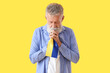 © Pixel-Shot - Mature man with flag of Ukraine praying on yellow background