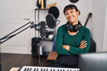 Sticker - Young beautiful hispanic woman musician smiling confident sitting with arms crossed gesture at music studio