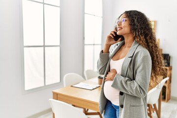 Sticker - Young latin woman pregnant smiling confident talking on the smartphone working at office