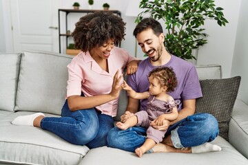 Couple and daughter smiling confident sitting on sofa at home