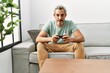 © Krakenimages.com - Middle age hispanic man playing video game sitting on the sofa thinking attitude and sober expression looking self confident