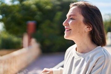 Wall Mural - Middle age woman smiling confident standing at park