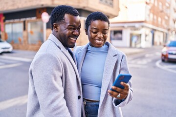 Poster - Man and woman couple standing together using smartphone at street