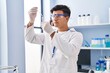 © Krakenimages.com - Young hispanic man scientist holding test tube with plant at laboratory