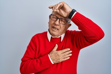 Wall Mural - Senior man with grey hair standing over isolated background touching forehead for illness and fever, flu and cold, virus sick