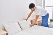 © Krakenimages.com - Young arab man smiling confident making bed at bedroom