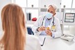 © Krakenimages.com - Middle age man and woman doctor and patient wearing medical mask holding pills at clinic