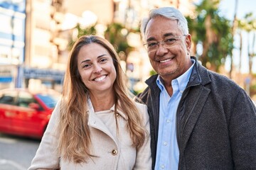 Canvas Print - Middle age man and woman couple smiling confident standing together at street