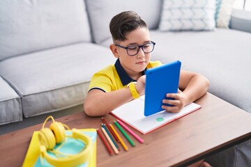 Sticker - Adorable hispanic boy using touchpad sitting on floor at home