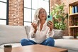 © Krakenimages.com - Middle age woman using smartphone holding pills at home