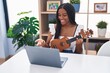 © Krakenimages.com - African american woman having online ukulele class at home
