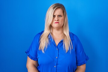 Sticker - Caucasian plus size woman standing over blue background skeptic and nervous, frowning upset because of problem. negative person.