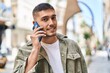 © Krakenimages.com - Young hispanic man smiling confident talking on the smartphone at street