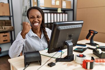 Canvas Print - African woman working at small business ecommerce angry and mad raising fist frustrated and furious while shouting with anger. rage and aggressive concept.