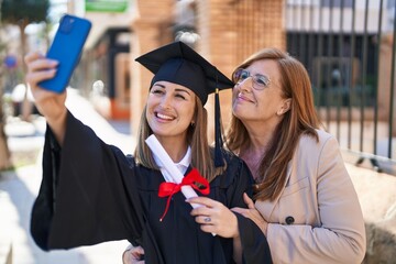 Poster - Mother and daughter making selfie by the smartphone celebrating graduation at university