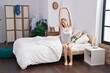 © Krakenimages.com - Young caucasian woman waking up stretching arms at bedroom