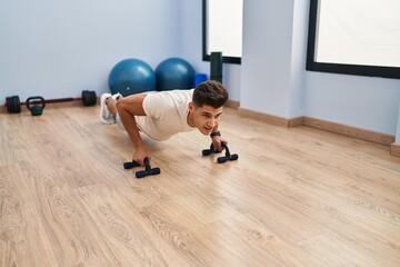 Sticker - Young hispanic man training push up at sport center
