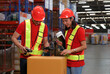 © atitaph - Asian male and female workers in safety suits wear hard hats. pack the product into a box
