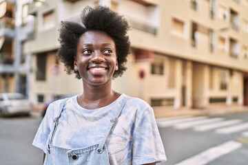 Wall Mural - Young african woman smiling confident at street