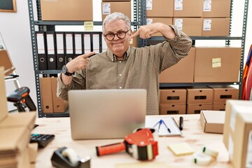 Poster - Senior caucasian man working at small business ecommerce with laptop smiling cheerful showing and pointing with fingers teeth and mouth. dental health concept.