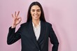 © Krakenimages.com - Young brunette woman wearing business style over pink background smiling positive doing ok sign with hand and fingers. successful expression.