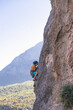 © zhukovvvlad - Children's rock climbing. The boy climbs a rock against the backdrop of mountains. Extreme hobby. An athletic child trains to be strong.