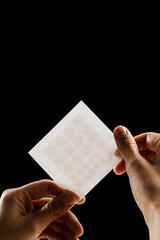 close-up acne patch for facial rejuvenation. set of round patches for acne in hands on black backgro