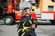 © Serhii - Portrait of rescued little boy with firefighter man standing near fire truck. Firefighter in fire fighting operation.