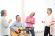 © Wongsakorn - Group of senior people enjoying with activities together. Elderly people having fun concept. Happy senior playing guitar and singing songs having fun together.