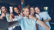 © silverkblack - Group of happy colleagues are taking selfie together, young man is holding camera and posing, his coworkers are holding drinks in bottles, laughing and looking at camera.
