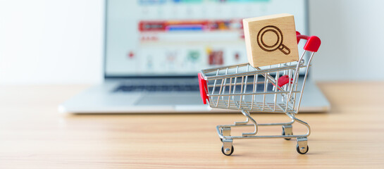 Shopping cart with Magnifying icon block and laptop computer with marketplace website, technology, ecommerce, SEO, Search Engine Optimization, Advertising, keyword and online payment concept