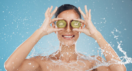 Canvas Print - Skincare, water and woman in studio with kiwi for cleaning, wellness and health against blue background mockup. Shower, fruit and girl model happy, smile and relax with green skin product for beauty