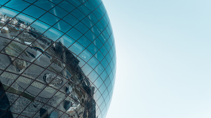 large glass blue sphere against the sky, exterior. modern futuristic architecture ball with reflecti