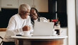 © Jacob Lund - Cheerful senior couple using a laptop together at home