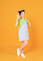 Wall Mural - Full length image of young Asian woman standing on background