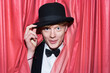 © Westend61 - Germany, Young magician behind curtain, smiling
