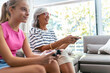 © Westend61 - Happy grandmother playing video game with granddaughter at home
