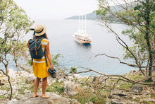 Croatia, Cres, Woman Standing At The Coast Looking At The Sea With Sailing Ship