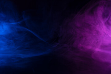 Wall Mural - clouds of blue and purple colored smoke swirling on black table background with reflection