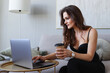 © makedonski2015 - Young woman working at home on laptop and drinking coffee. Remote work from home during the pandemic