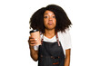 © Asier - Young african american woman barista holding a takeaway coffee shrugs shoulders and open eyes confused.