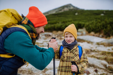 Wall Mural - Father with his little son hiking in mountains together.