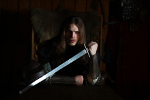 A Mighty Hero With Long Hair In Chain Mail Armor In An Ancient Hall. Medieval Warrior In The Knight's Chambers.